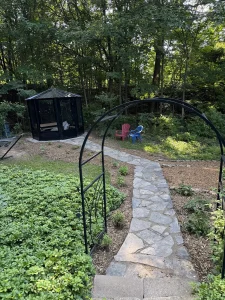 Lumen Landscaping | Gardening Flagstone garden path under a metal arch