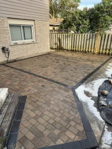 Lumen Landscaping | Interlock Interlock side yard patio with a dark soldier course border