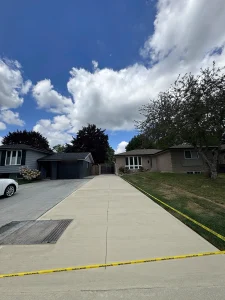 Lumen Landscaping | Mississauga Long new concrete driveway with control joints, taped off while it cures